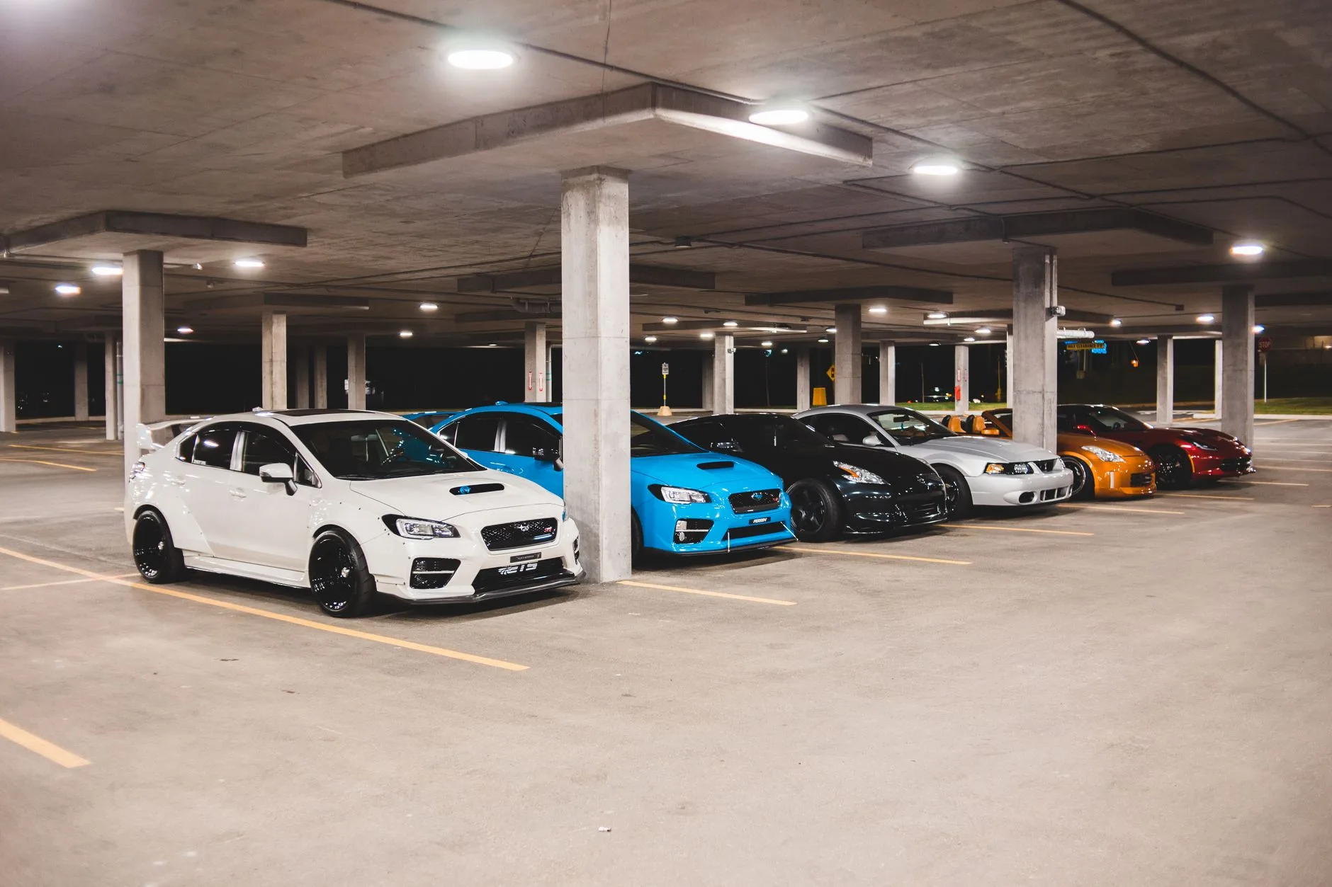 Collection of luxury and sports cars parked inside a private garage.