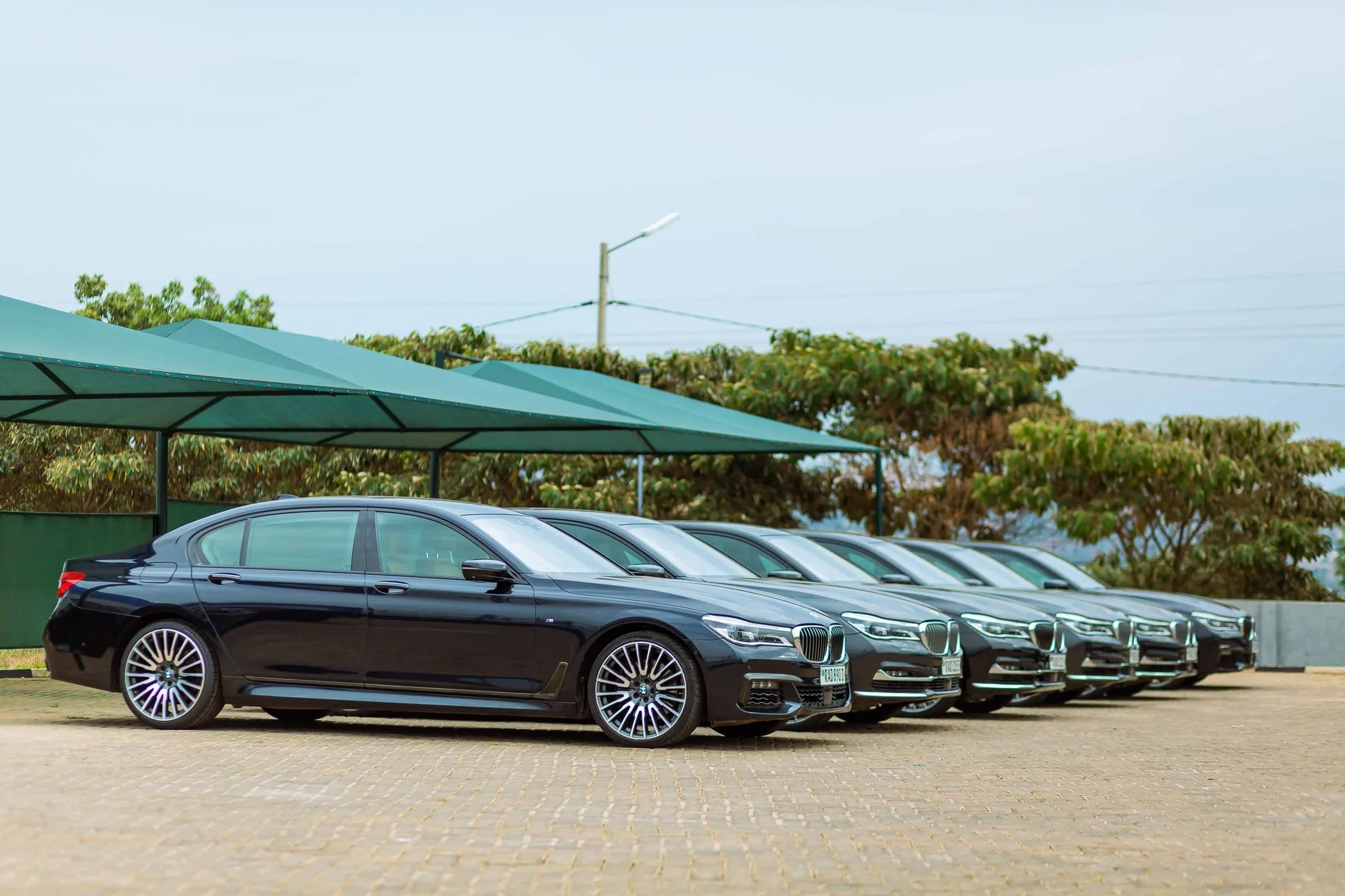 Row of luxury and sports cars lined up in a showroom-style display.
